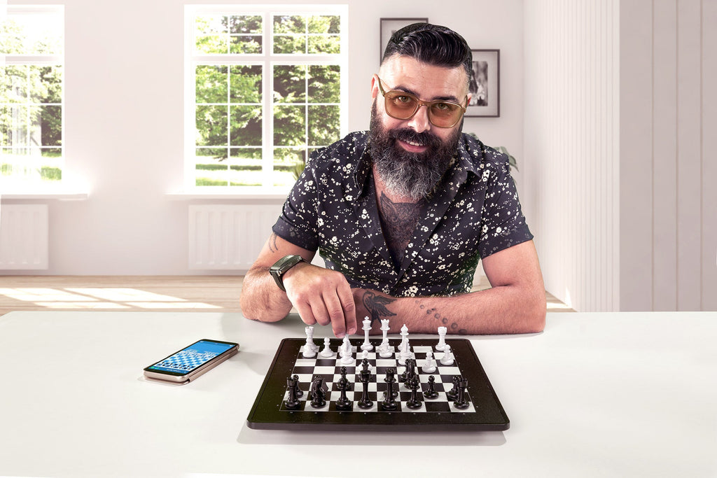 Man playing chess against computer Stock Photo